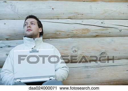 Young man dressed in winter clothing, using laptop View Large Photo Image Stock Image - Young man dressed in winter clothing, using laptop. Fotosearch