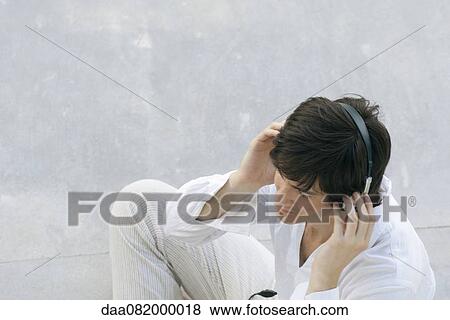 Young man listening to headphones View Large Photo Image Stock Photo - Young man listening to headphones. Fotosearch