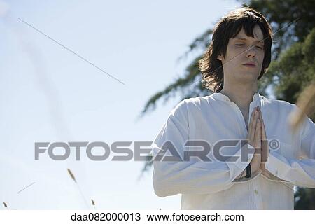 Young man meditating outdoors View Large Photo Image Stock Image - Young man meditating outdoors. Fotosearch