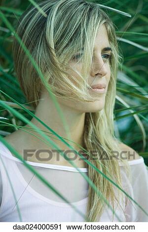 Young woman among foliage, hair being blown by breeze, portrait View Large Photo Image Stock Image - Young woman among foliage, hair being blown by breeze, portrait. Fotosearch