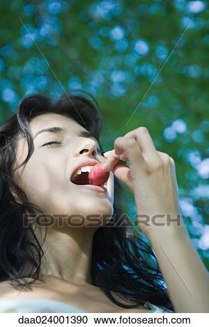 Young woman biting into radish, low angle view View Large Photo Image Stock Image - Young woman biting into radish, low angle view. Fotosearch