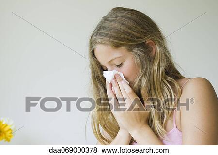 Stock Photo - Young woman blowing her nose. Fotosearch