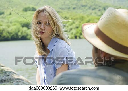 Young woman by lake, man in foreground View Large Photo Image Stock Photo - Young woman by lake, man in foreground. Fotosearch
