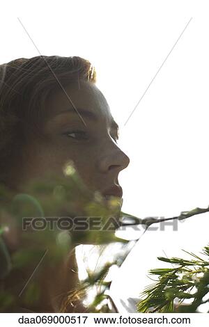 Stock Photo - Young woman by tree branch, cropped. Fotosearch