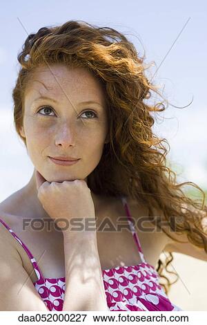 Stock Photo - Young woman daydreaming, portrait. Fotosearch