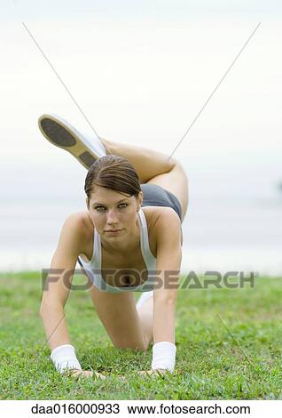 Young woman doing stretching exercises by lakeside View Large Photo Image Stock Image - Young woman doing stretching exercises by lakeside. Fotosearch