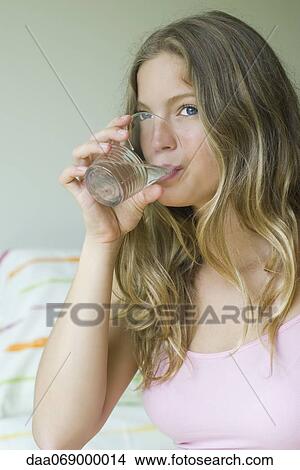 Picture - Young woman drinking glass of water. Fotosearch