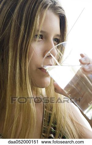 Stock Image - Young woman drinking glass of water. Fotosearch