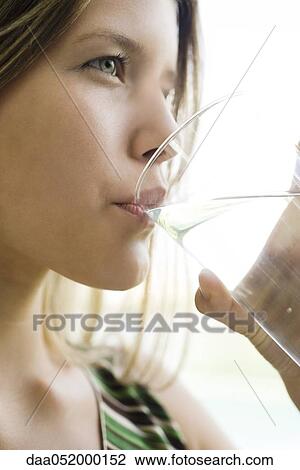 Stock Image - Young woman drinking glass of water. Fotosearch