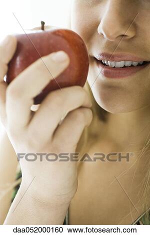 Stock Image - Young woman eating apple. Fotosearch