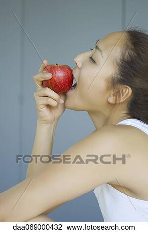 Stock Image - Young woman eating apple. Fotosearch