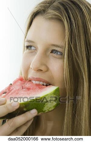 Young woman eating slice of watermelon View Large Photo Image Stock Photograph - Young woman eating slice of watermelon. Fotosearch