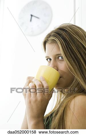 Stock Photo - Young woman enjoying cup of coffee, portrait. Fotosearch