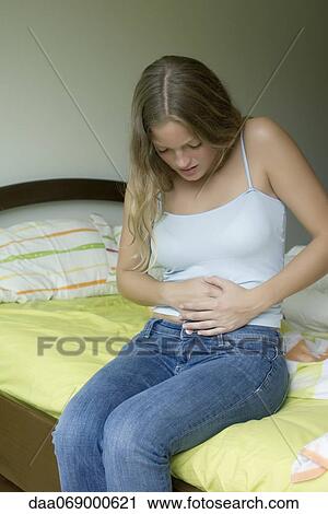 Stock Image - Young woman experiencing abdominal pain. Fotosearch