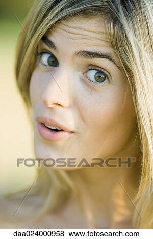 Young woman giving sideways glance at camera, portrait, close-up View Large Photo Image Stock Photo - Young woman giving sideways glance at camera, portrait, close-up. Fotosearch
