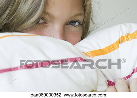 Young woman hiding face in pillow, portrait View Large Photo Image Stock Image - Young woman hiding face in pillow, portrait. Fotosearch