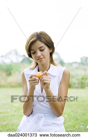 Young woman holding apricot, waist up View Large Photo Image Stock Image - Young woman holding apricot, waist up. Fotosearch
