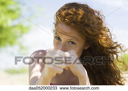 Young woman holding clenched fists toward camera View Large Photo Image Stock Image - Young woman holding clenched fists toward camera. Fotosearch