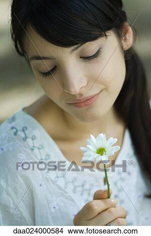 Picture - Young woman holding flower, portrait. Fotosearch