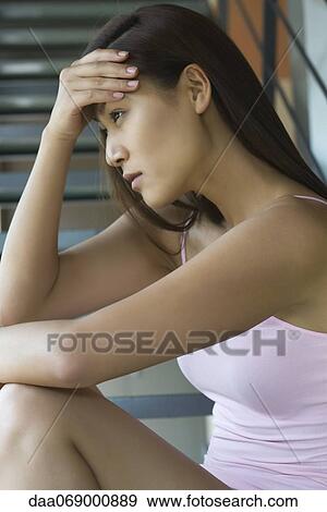 Stock Photo - Young woman holding head. Fotosearch