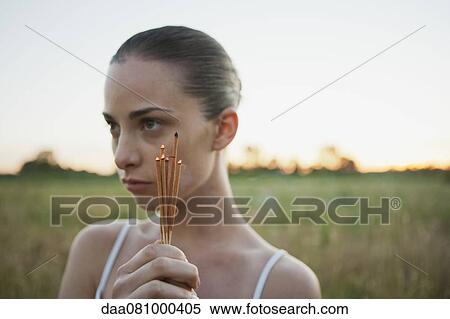 Young woman holding incense sticks outdoors View Large Photo Image Stock Photography - Young woman holding incense sticks outdoors. Fotosearch