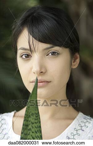 Young woman holding leaf, portrait View Large Photo Image Stock Image - Young woman holding leaf, portrait. Fotosearch