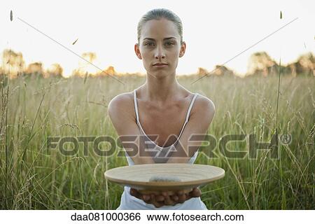 Young woman holding out plate with stone View Large Photo Image Stock Photograph - Young woman holding out plate with stone. Fotosearch