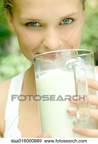 Young woman holding pitcher of milk to mouth View Large Photo Image Stock Photo - Young woman holding pitcher of milk to mouth. Fotosearch