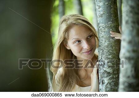 Young woman holding tree trunks View Large Photo Image Stock Photography - Young woman holding tree trunks. Fotosearch