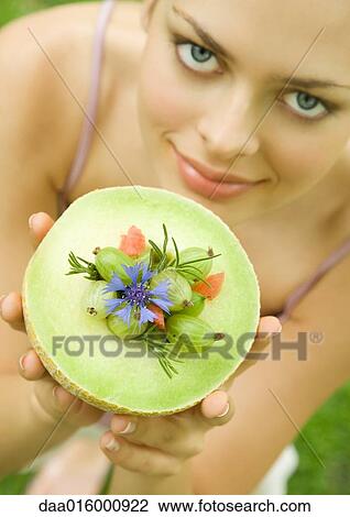 Young woman holding up melon bowl of fruit View Large Photo Image Stock Image - Young woman holding up melon bowl of fruit. Fotosearch