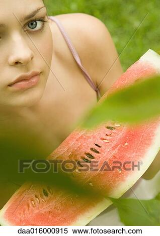 Stock Photography - Young woman holding up slice of watermelon. Fotosearch