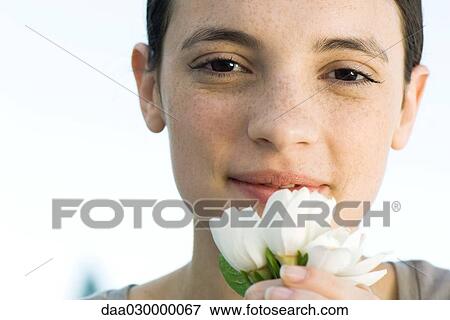 Young woman holding white flowers up to face View Large Photo Image Stock Photo - Young woman holding white flowers up to face. Fotosearch