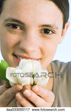Young woman holding white flowers up to face View Large Photo Image Stock Photo - Young woman holding white flowers up to face. Fotosearch