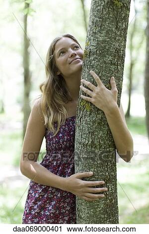 Young woman hugging tree View Large Photo Image Stock Image - Young woman hugging tree. Fotosearch
