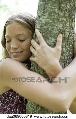 Young woman hugging tree with eyes closed View Large Photo Image Stock Photo - Young woman hugging tree with eyes closed. Fotosearch