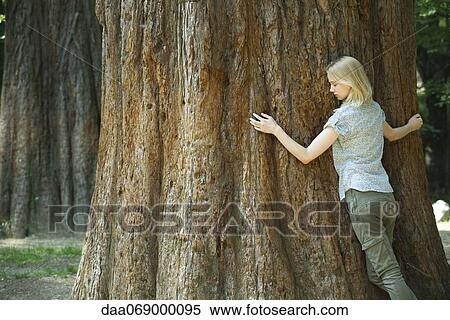 Young woman hugging tree with eyes closed View Large Photo Image Stock Photography - Young woman hugging tree with eyes closed. Fotosearch