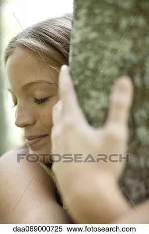 Young woman hugging tree with eyes closed, cropped View Large Photo Image Stock Photography - Young woman hugging tree with eyes closed, cropped. Fotosearch