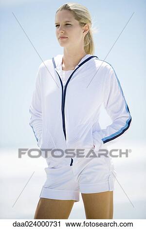 Young woman in active wear, standing on beach View Large Photo Image Stock Image - Young woman in active wear, standing on beach. Fotosearch