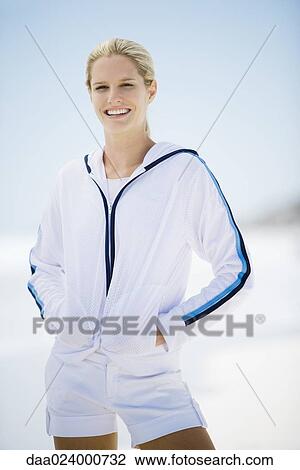 Young woman in active wear, standing on beach View Large Photo Image Stock Image - Young woman in active wear, standing on beach. Fotosearch