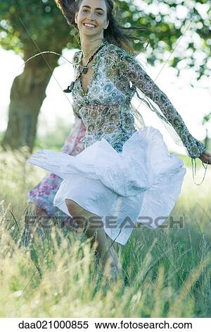 Stock Photography - Young woman in field, jumping. Fotosearch