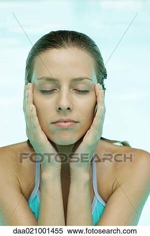 Young woman in pool, eyes closed, hands on side of face View Large Photo Image Stock Photography - Young woman in pool, eyes closed, hands on side of face. Fotosearch