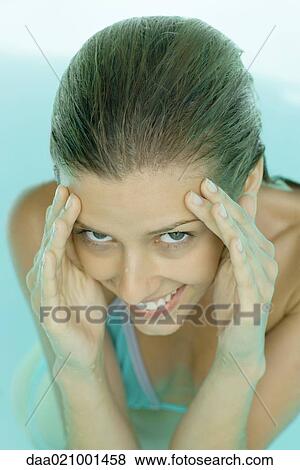 Young woman in pool, hands on side of face, smiling at camera View Large Photo Image Stock Photo - Young woman in pool, hands on side of face, smiling at camera. Fotosearch