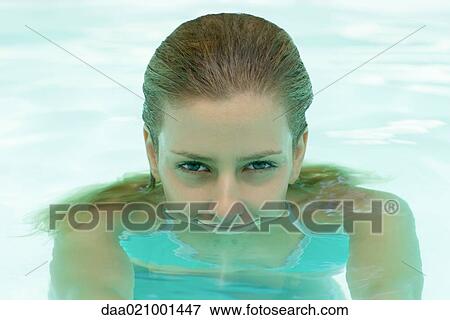 Stock Photo - Young woman in pool, head emerging from water. Fotosearch