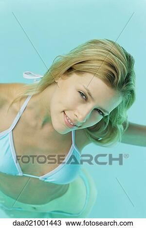 Young woman in pool, smiling at camera View Large Photo Image Stock Image - Young woman in pool, smiling at camera. Fotosearch