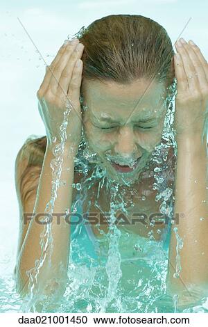Young woman in pool, splashing face with water View Large Photo Image Stock Image - Young woman in pool, splashing face with water. Fotosearch