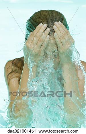 Young woman in pool, splashing face with water View Large Photo Image Stock Image - Young woman in pool, splashing face with water. Fotosearch
