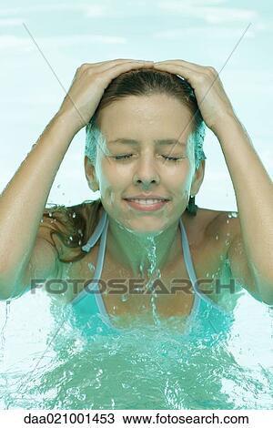 Young woman in pool, splashing face with water View Large Photo Image Stock Image - Young woman in pool, splashing face with water. Fotosearch