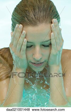 Young woman in pool, splashing face with water View Large Photo Image Stock Photo - Young woman in pool, splashing face with water. Fotosearch