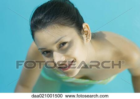 Young woman in pool wearing bikini, looking up at camera, close-up, high angle view View Large Photo Image Stock Image - Young woman in pool wearing bikini, looking up at camera, close-up, high angle view. Fotosearch
