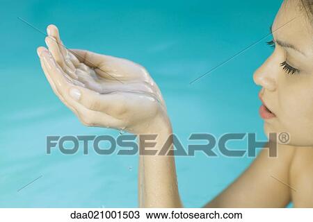 Young woman in water, holding up cupped hands, cropped view View Large Photo Image Stock Image - Young woman in water, holding up cupped hands, cropped view. Fotosearch